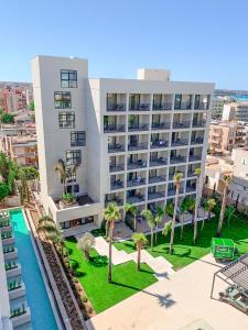 帕尔马海滩Hotel Paradiso Garden的享有带游泳池和棕榈树的建筑的空中景致