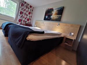 Laxå拉桑断点酒店的一间卧室配有一张带木制床头板的床