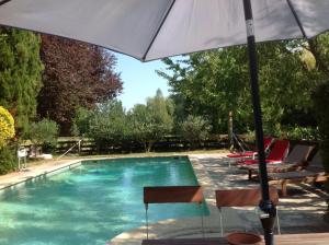 蒙特La Jacquemarie的游泳池旁的遮阳伞和椅子