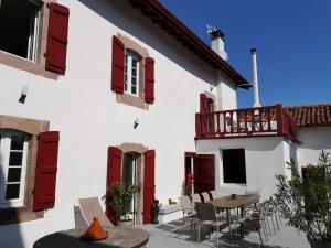 LouhossoaChalbonia的白色的建筑,设有红色百叶窗和桌椅