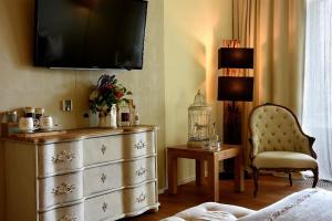 滨湖瓦京康体花园酒店的卧室配有梳妆台,墙上配有电视