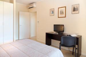 佩鲁贾城市公寓酒店的一间卧室配有一张床和一张带电脑的书桌