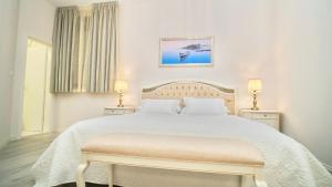 特罗吉尔Hotel Bellevue Trogir的白色卧室配有一张大床和两盏灯。