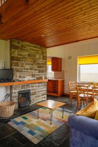 阿基尔Butterfly Cottage的客厅设有石制壁炉和桌子。