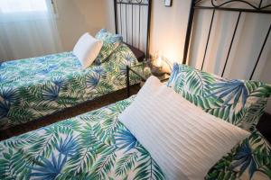 贝纳尔马德纳Villa La Tuna的一间卧室设有两张床和一张棕榈叶床。
