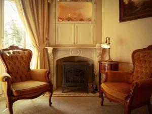 阿珀尔多伦天马大酒店的客厅配有两把椅子和壁炉