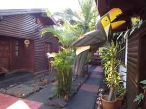 伊瓜苏港Si Mi Capitán - Cabañas & Habitaciones的鸟在房子边的雕像