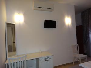 切萨雷奥港Relax Affittacamere的客房设有书桌和墙上的电视。