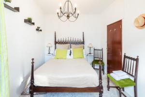 BrinchesCasa dos Moinhos Velhos的一间卧室配有一张床和一个吊灯
