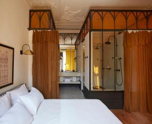 波尔图Cocorico Luxury House - Porto的一间卧室设有一张床和一个玻璃淋浴间