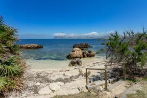 瓦尔德利切La Tonnara di Bonagia Resort的海滩上有岩石,水中有楼梯