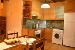 AgulloCasa Ros的厨房配有桌子、洗衣机和烘干机
