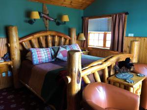 博尔顿兰丁Lake George Boathouse Waterfront Lodging的一间卧室配有一张木床和一把椅子