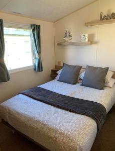塞顿港Edinburgh, seton sands的一间卧室配有一张带蓝色枕头的床和一扇窗户。