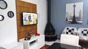 格拉玛多Glamour Gramado Residence的一间带电视和壁炉的客厅