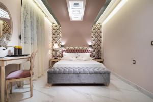 新马尔马拉斯Pela Veranda Exquisite Suites的一间卧室配有一张床、一张桌子和一把椅子
