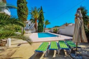 莫莱拉Aldebarán - Costa Blanca holiday rental with private pool的一个带2把躺椅和遮阳伞的游泳池