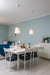尼亚普拉莫斯Casa di Emma的一间配备有白色桌椅的用餐室