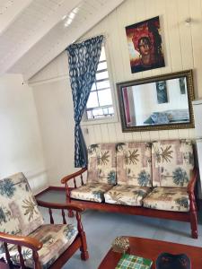 Calibishie雷恩博海滩公寓的客厅配有沙发和两把椅子