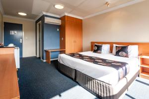 霍巴特黑水牛酒店的酒店客房设有一张大床和一张书桌。