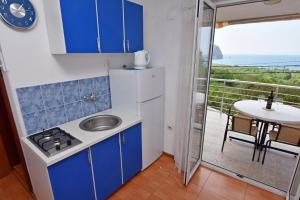 佩特罗瓦纳莫鲁Apartments Siljak的一个带蓝色橱柜和水槽的厨房和一个阳台