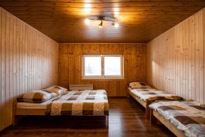 HriňováWellness Chalet Harmonia的配有木墙和窗户的客房内的两张床