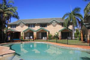 科夫斯港水上别墅公寓度假村的棕榈树屋前的游泳池