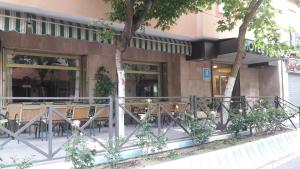 兰哈龙Hotel Paraíso的大楼前设有桌椅的餐厅