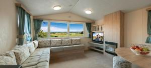 塞顿港Edinburgh, seton sands的客厅配有大沙发和电视