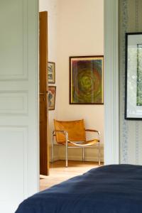 SkegrieLiebacksgården的卧室配有椅子和墙上的绘画