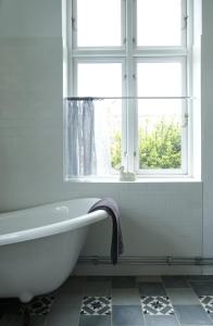 SkegrieLiebacksgården的带窗户的浴室内的白色浴缸