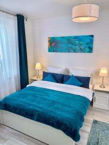 莱茵河畔林茨Im kleinen Stil l的一间卧室配有一张带蓝色毯子的床