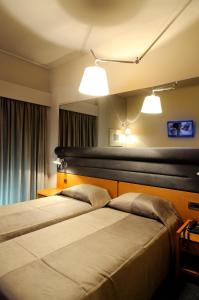 斯巴达玛尼阿缇斯酒店的配有2盏灯的酒店客房的2张床