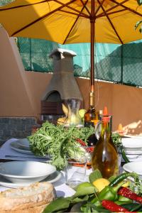 因佩里亚Appartamenti Villa Chiara的一张桌子,上面放着盘子和黄伞