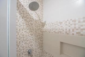 三宝垄RedDoorz near MT Haryono Semarang的浴室设有棕色瓷砖和淋浴。