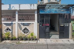三宝垄RedDoorz near MT Haryono Semarang的一座有门和植物的建筑的入口