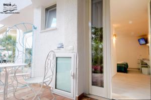 卡拉·利贝罗托Villa Dessena Bed and Breakfast的玻璃门通向带桌椅的阳台