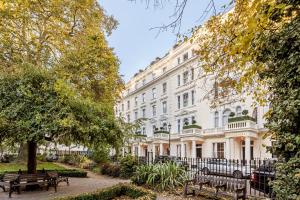 伦敦伦敦海德公园美居酒店的前面有长椅的白色建筑