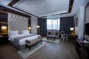 巴库蓝宝石大酒店的一间大卧室,配有一张大床和一把椅子