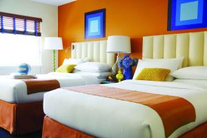旧金山Hotel Del Sol的橙色墙壁的客房内的三张床