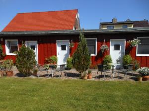 普特布斯Alte Schmiede Putbus的院子里的红色房子,配有桌椅