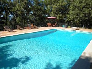 阿雷佐Residence Gello的一个带椅子和遮阳伞的大型蓝色游泳池