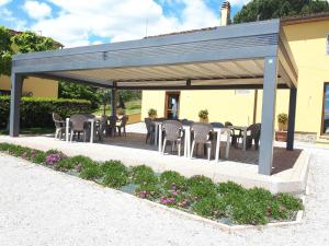 塞拉瓦莱皮斯托耶塞Agriturismo Villa Bracali的一个带桌椅和鲜花的凉亭
