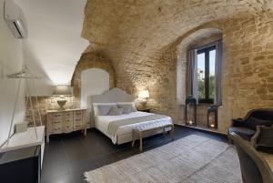 拉古萨Itria Palace的一间卧室设有一张床和石墙