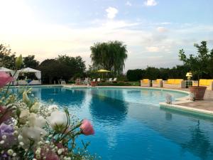 加拉托内Tenuta DonnAnna Agriturismo&Glamping的一座拥有蓝色海水和鲜花的游泳池