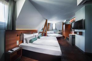 慕尼黑Maison Schiller by DesignCity Hotels的卧室配有一张白色大床和电视。