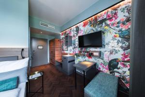 慕尼黑Maison Schiller by DesignCity Hotels的一间酒店客房,配有一张床和一台墙上的电视