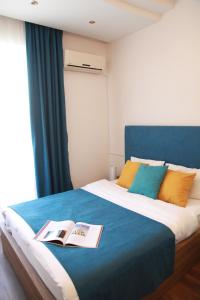 第比利斯里约酒店的一间卧室配有一张床,上面有两本书