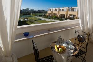 夸尔图-圣埃莱娜Residence Mar Mediterraneo的一张桌子,上面放着一碗水果,上面放着窗户