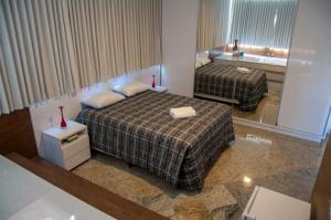 波苏斯-迪卡尔达斯Hotel Pousada Beija Flor的酒店客房带两张床和一间浴室